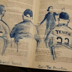 Art by Andy Brown depicting me in "librarian mode" in glasses, bun, and cardigan sweater, leading a session at the sabr convention on baseball research and publications, painted on the artist's program book