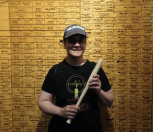 Cecilia Tan holding a mini bat at the Louisville Slugger Museum